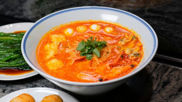 Delicious Thai Tom Yum soup with seafood and vegetables, garnished with cilantro in a ceramic bowl.