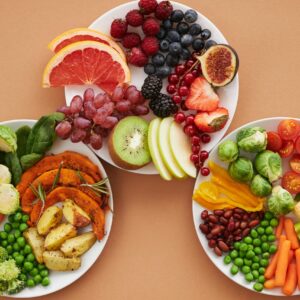 Top view of vibrant plates of fresh fruits and vegetables, perfect for a healthy lifestyle.